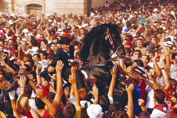 Rider on a rearing horse among the crowds during Sant Joans festival