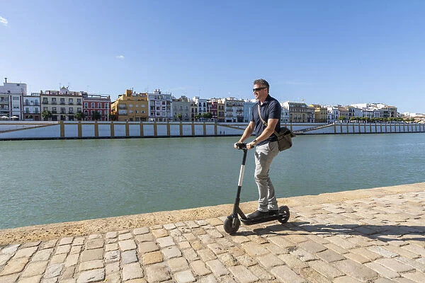 Riding an e-scooter in Seville, Andalusia, Spain, Europe
