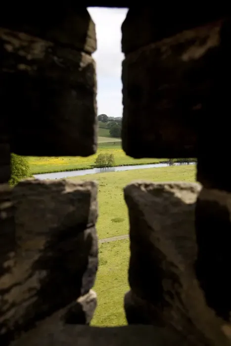 Framed Print : River Aln seen through arrow slit of the walls of Alnwick Castle, Northumberland Framed Print : River Aln seen through arrow slit of the walls of Alnwick Castle, Northumberland