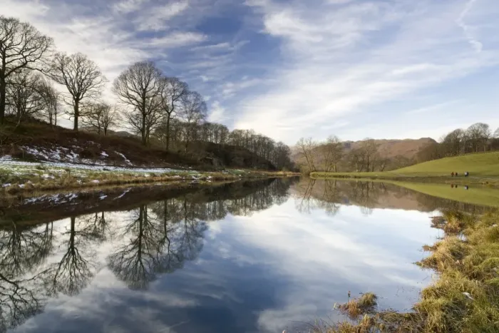 Framed Print : River Brathay on a calm winters day with reflections of trees and distant fells Framed Print : River Brathay on a calm winters day with reflections of trees and distant fells