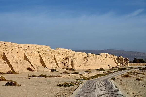 Road past ruined city wall of ancient Silk Road city of Gaochang, Taklamakan desert