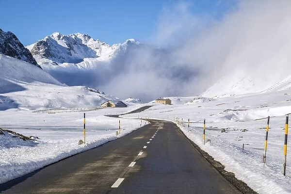 The road runs through the snow covered valley, Albula Pass, Engadine, Graubunden