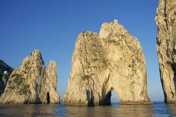 Rock arches known as the Faraglioni Stacks off the
