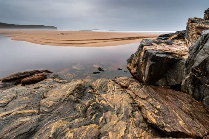 Framed Print : Rock formations at Sandwood Bay, with Am Buachaille sea stack in far distance, Sutherland Framed Print : Rock formations at Sandwood Bay, with Am Buachaille sea stack in far distance, Sutherland