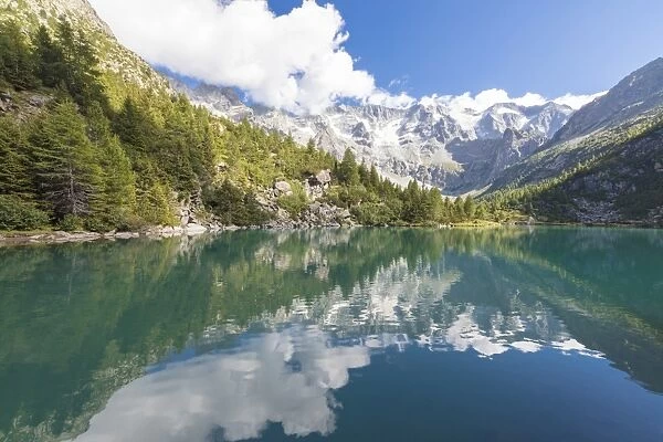 Rocky peaks and woods are reflected in Lago Aviolo, Vezza d Oglio, Camonica Valley