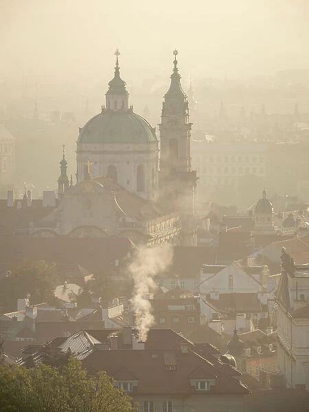 Rooftops and St. Nicholas Church at sunrise from Petrin Hill in autumn, Prague, Czechia (Czech Republic), Europe