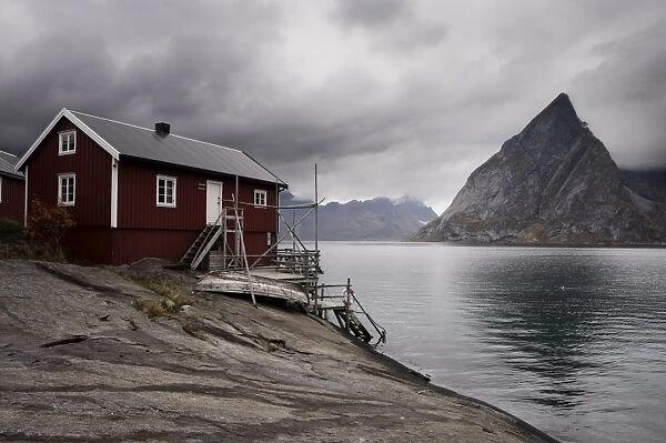 Rorbuer (fishermens huts) on fjord with mountains, Lofoten Islands