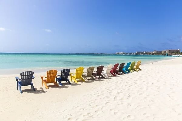 A row of colourful wooden deckchairs on Palm Beach, Aruba, Netherlands Antilles, Caribbean