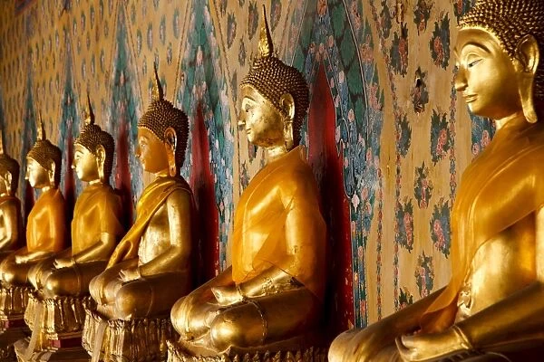 A row of golden seated Buddha statues located inside Wat Arun (The Temple of the Dawn)