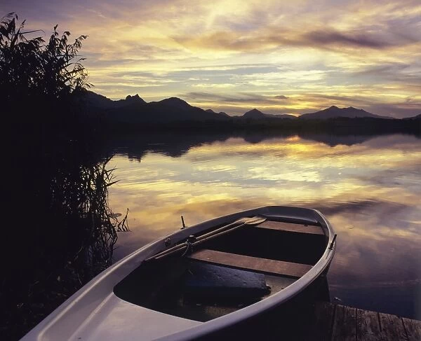 Rowing boat on Hopfensee Lake at sunset, near Fussen, Allgau, Bavaria, Germany, Europe