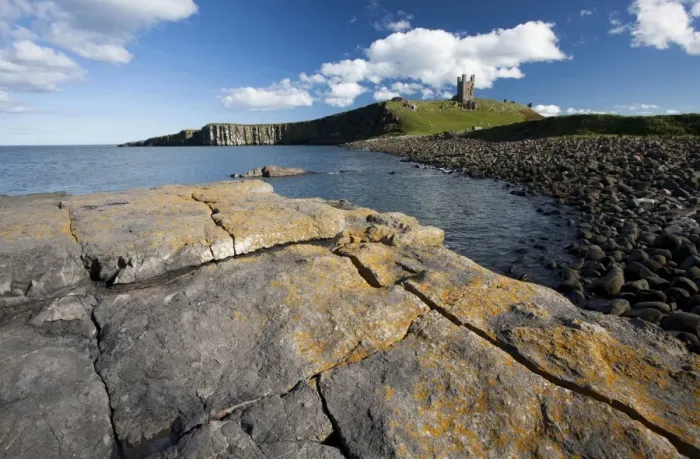 Framed Print : The ruins of Dunstanburgh Castle in the distance viewed from Greymare Rock on a sunny summers afternoon, Embleton Bay, Northumberland Framed Print : The ruins of Dunstanburgh Castle in the distance viewed from Greymare Rock on a sunny summers afternoon, Embleton Bay, Northumberland