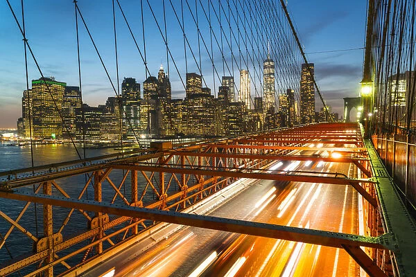 Rush hour traffic at night on Brooklyn Bridge and Manhattan skyline beyond, New York City