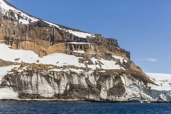 Rust-colored volcanic tuff cliffs above a dark material filled glacier at Brown Bluff, eastern side of the Tabarin Peninsula, Weddell Sea, Antarctica, Polar Regions