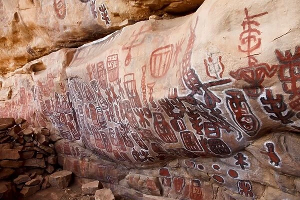 Sacred rock paintings on cliff depicting Dogon customs and stories in Songo
