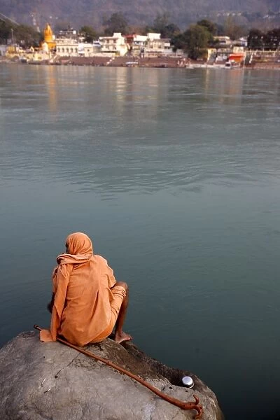 Sadhu sitting by the River Ganges in Rishikesh, Uttarakhand, India, Asia
