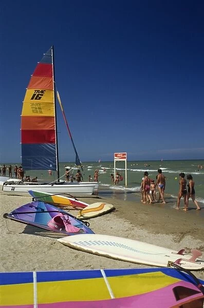 Sailing boats and windsurfing boards on beach at Rimini