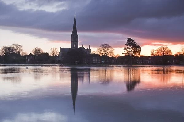 Salisbury Cathedral at dawn reflected in the flooded West Harnham Water Meadows, Salisbury, Wiltshire, England, United Kingdom, Europe