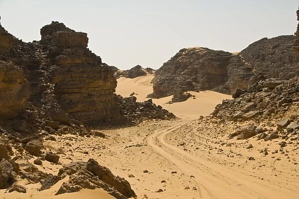 Sandy trail leading through the desert, Tin Ghas, Southern Algeria, North Africa, AFrica