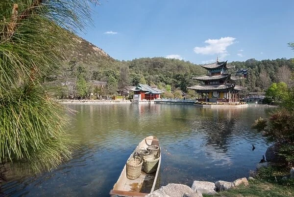 Scene at Black Dragon Pool (Heilongtan) with boat carrying wicker baskets and Moon Embracing Pavilion, Lijiang, Yunnan, China, Asia