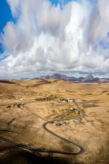 Framed Print : Scenic clouds on winding road running through desert mountains, aerial view, Tefia Framed Print : Scenic clouds on winding road running through desert mountains, aerial view, Tefia