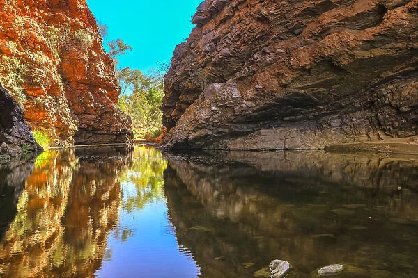 Scenic Simpsons Gap and permanent waterhole reflecting the cliffs in West MacDonnell