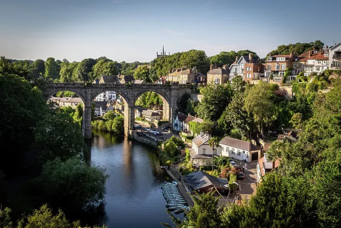 Framed Print : Scenic view of an old arched bridge over a tranquil River Nidd with surrounding greenery and houses in a quaint village in Knaresborough, North Yorkshire, England, United Kingdom, Europe Framed Print : Scenic view of an old arched bridge over a tranquil River Nidd with surrounding greenery and houses in a quaint village in Knaresborough, North Yorkshire, England, United Kingdom, Europe