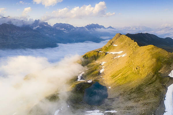 Schwarziseeli lake and Stotzigen Firsten mountain emerging from a sea of clouds