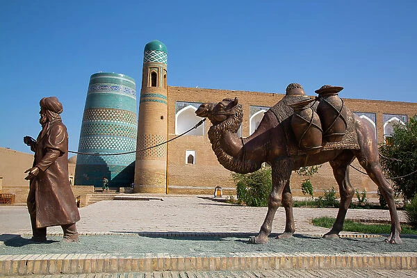 Sculpture of Camel Train, Kalta Minaret in the background, Ichon Qala (Itchan Kala), UNESCO World Heritage Site, Khiva, Uzbekistan, Central Asia, Asia