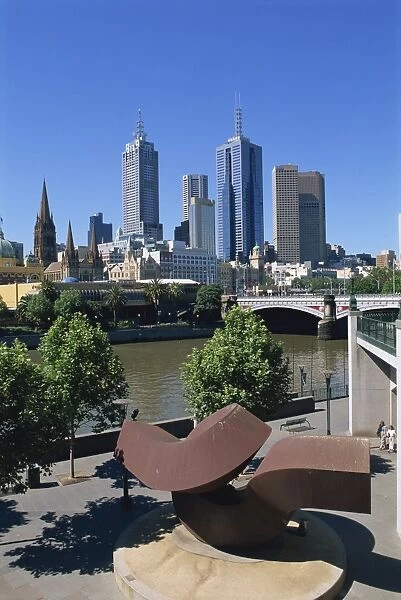 Sculpture on Yarra River embankment and city skyline, Melbourne, Victoria