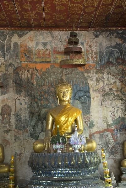 Seated Buddha statue with murals in the background, Wat Pak Huak, Luang Prabang, Laos, Indochina, Southeast Asia, Asia