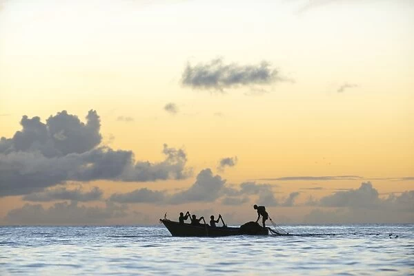 Seine fisherman lay their nets from a boat in Castara Bay in Tobago at sunset, Trinidad and Tobago