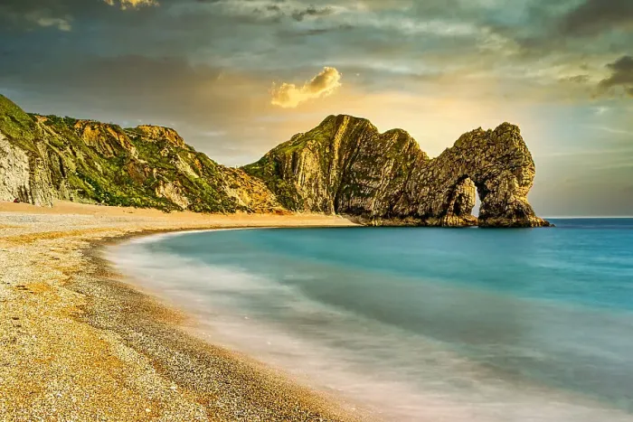 Framed Print : Serene beach with smooth waters, golden sand, and rugged cliffs under a sunset sky at Durdle Door, Jurassic Coast, UNESCO World Heritage Site, Dorset, England, United Kingdom, Europe