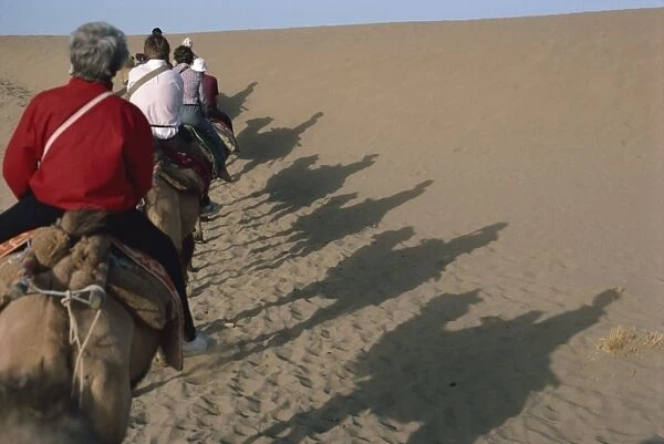 Shadows of tourists on camels, Dunhuang Province, China, Asia