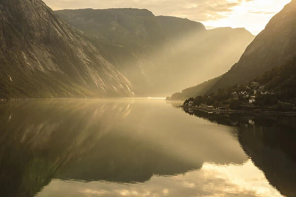 Shafts of light enter misty, beautiful Eidfjord, fjord reflections, Hardangerfjord
