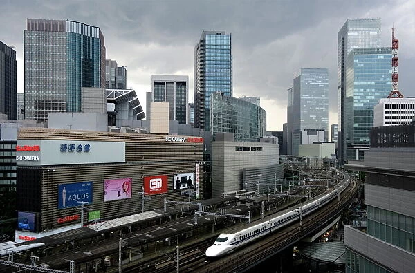 Shinkansen bullet train weaving through maze of buildings in the Yurakucho district of downtown Tokyo