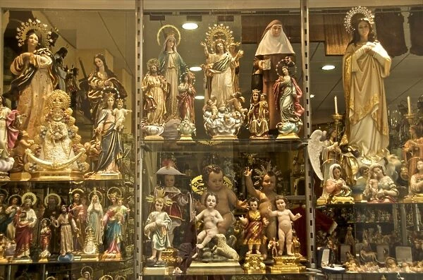 Shop window of a religious articles shop with virgins, angels, and Christ for sale
