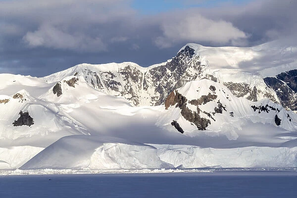 Shorefast ice and snow covered mountains in early season in Wilhamena Bay, Antarctica