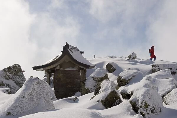 Shrine and climber on snow covered Iwaki San mountain, Aomori prefecture, Japan, Asia