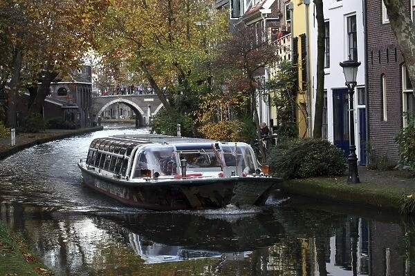 A sightseeing barge tours along the Oudegracht Canal in the Dutch city of Utrecht