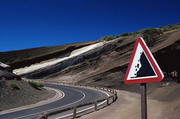 Sign on road with stratified volcanic rocks in the background, Parque Nacional del Teide
