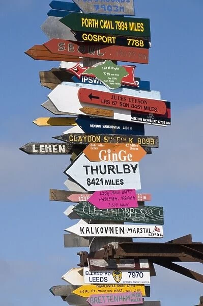 Signs with mileage to world destinations made into a totem pole, Port Stanley