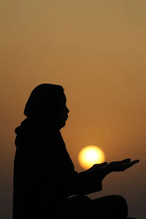 Framed Print : Silhouette of a Muslim woman in abaya praying with her hands at sunset Framed Print : Silhouette of a Muslim woman in abaya praying with her hands at sunset