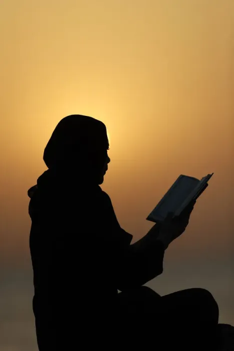 Framed Print : Silhouette of a Muslim woman reading the Noble Quran at sunset, United Arab Emirates Framed Print : Silhouette of a Muslim woman reading the Noble Quran at sunset, United Arab Emirates