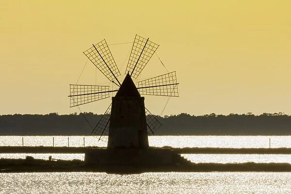 Silhouette of old windmill used to raise water from the Stagnone Lagoon into salt pans south of Trapani, Marsala, Sicily, Italy, Mediterranean, Europe