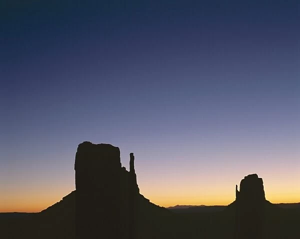 Silhouettes of mitten rock formations at sunset