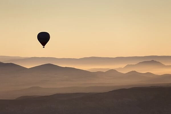 Single hot air balloon over a misty dawn sky, Cappadocia, Anatolia, Turkey, Asia Minor, Eurasia