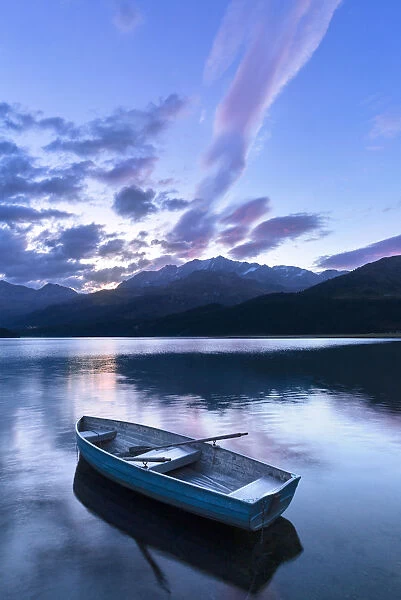 Single moored boat in the Lake of Sils at sunrise, Maloja pass, Engadine valley