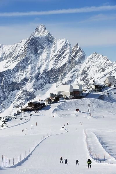 Skiers skiing on a ski run, mountain scenery in Cervinia ski resort, Cervinia