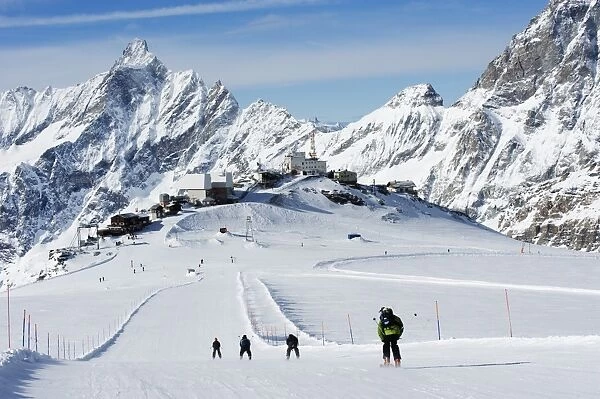 Skiers skiing on a ski run, mountain scenery in Cervinia ski resort, Cervinia