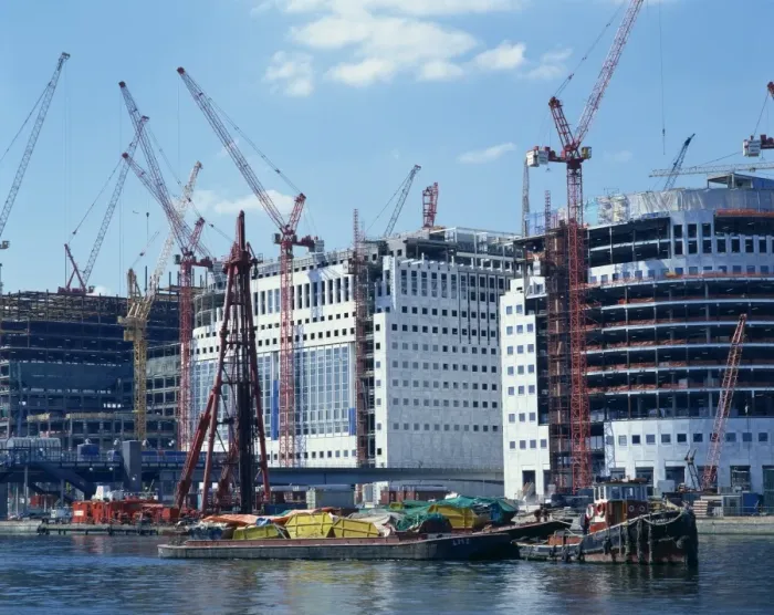 Framed Print : Skips on barges and cranes in front of buildings under construction in the Docklands Framed Print : Skips on barges and cranes in front of buildings under construction in the Docklands